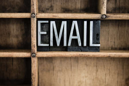 The word "EMAIL" written in vintage metal letterpress type in a wooden drawer with dividers.の写真素材