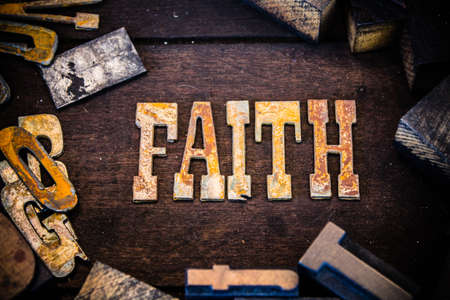 The word faith written in rusted metal letters surrounded by vintage wooden and metal letterpress type.の写真素材