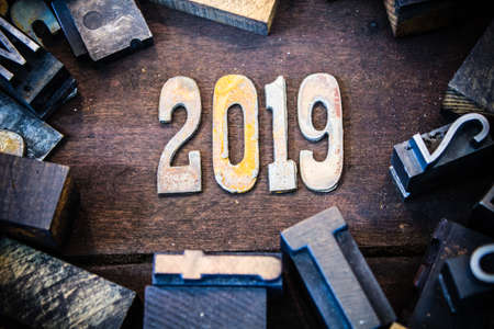 The year 2019 written in rusted metal letters surrounded by vintage wooden and metal letterpress type.の写真素材