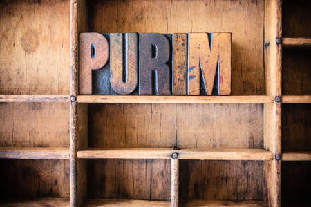 The word PURIM written in vintage wooden letterpress type in a wooden type drawer.の写真素材