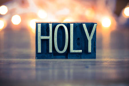 The word HOLY written in vintage metal letterpress type on a soft backlit background.の写真素材