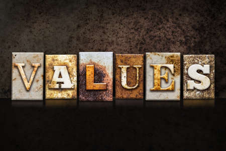 The word "VALUES" written in rusty metal letterpress type on a dark textured grunge background.の写真素材
