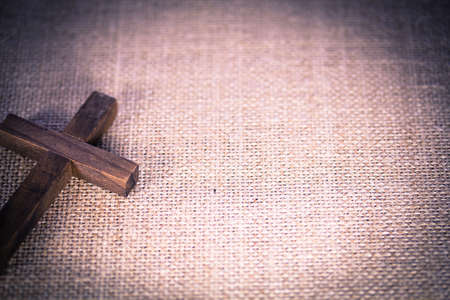 An aerial view of a holy wooden Christian cross on a burlap background.の写真素材