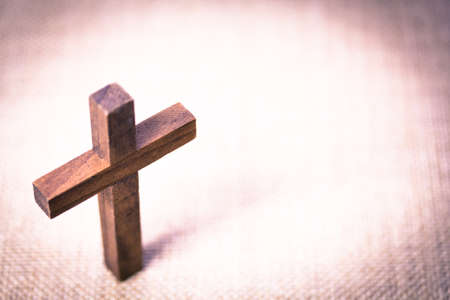 An aerial view of a holy wooden Christian cross on a burlap background.の写真素材