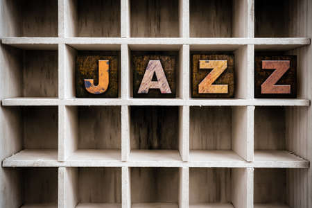 The word "JAZZ" written in vintage ink stained wooden letterpress type in a partitioned printer's drawer.の写真素材