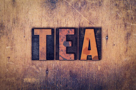 The word "Tea" written in dirty vintage letterpress type on a aged wooden background.の写真素材
