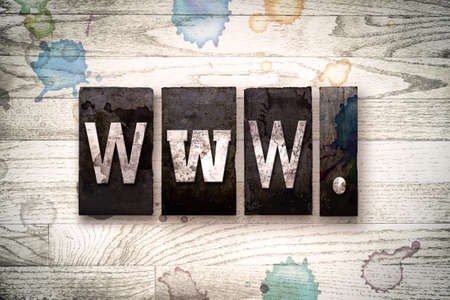 The word "WWW" written in vintage dirty metal letterpress type on a whitewashed wooden background with ink and paint stains.の写真素材
