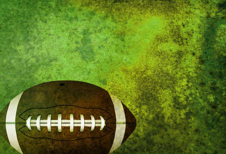 A green textured American football field background with ball. Room for copy.の写真素材