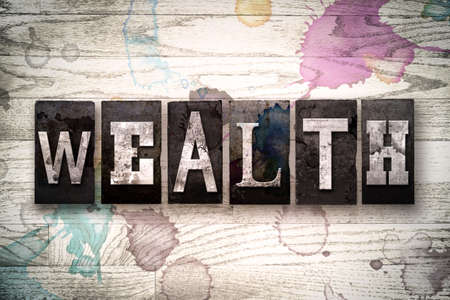 The word "WEALTH" written in vintage, dirty metal letterpress type on a whitewashed wooden background with ink and paint stains. The word "WEALTH" written in vintage, dirty metal letterpress type on a whitewashed wooden background with ink and paint stains.