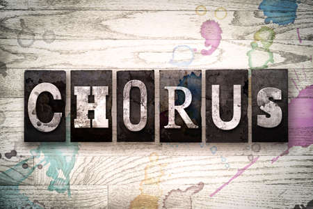 The word "CHORUS" written in vintage, dirty metal letterpress type on a whitewashed wooden background with ink and paint stains.の写真素材