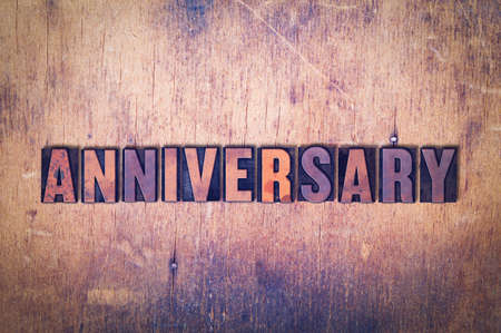The word Anniversary concept and theme written in vintage wooden letterpress type on a grunge background.の写真素材
