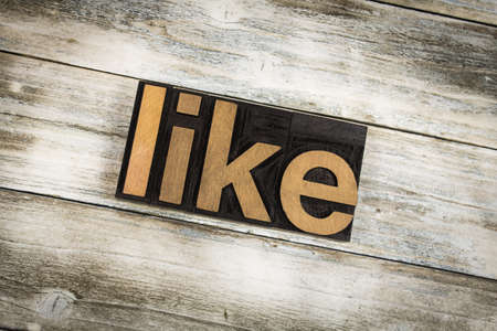The word "like" written in wooden letterpress type on a white washed old wooden boards background.の写真素材