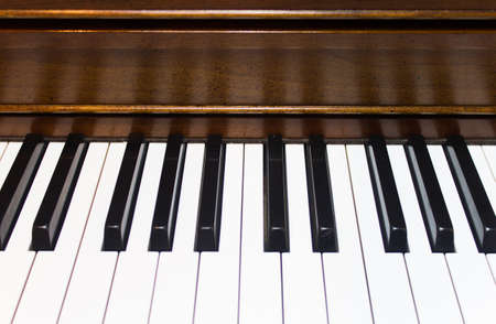 Black and white piano keys and wooden piano background
