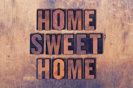 The words Home Sweet Home concept and theme written in vintage wooden letterpress type on a grunge background.の写真素材