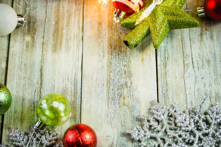 A set of Christmas holiday lights and ornaments on a white washed vintage wood background.