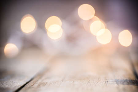 An abstract background of soft bokeh lights and a wooden floor.