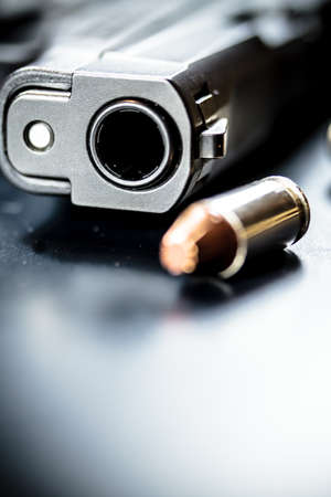 A black pistol hand gun with bullets.
