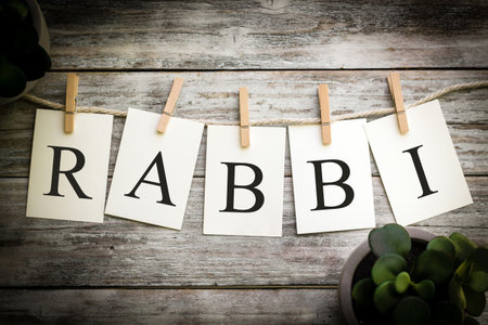 A set of printed cards spelling the word RABBI on an aged wooden background.の写真素材