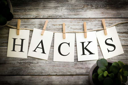 A set of printed cards spelling the word HACKS on an aged wooden background.の写真素材