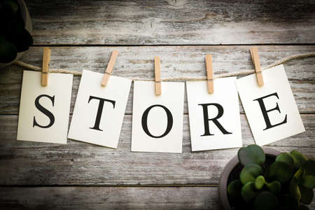 A set of printed cards spelling the word STORE on an aged wooden background.の写真素材