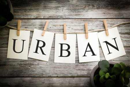 A set of printed cards spelling the word URBAN on an aged wooden background.の写真素材