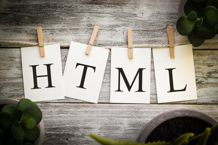 A set of printed cards spelling the word HTML on an aged wooden background.の写真素材