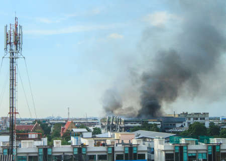 Fire burning and black smoke over the factoryの写真素材