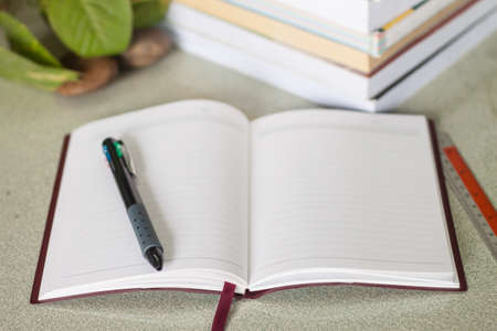Notebook and pile of books on the table