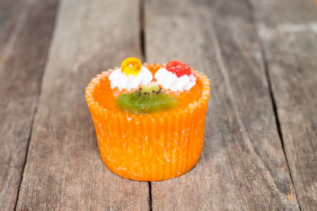 orange and kiwi cupcake on wood tableの写真素材