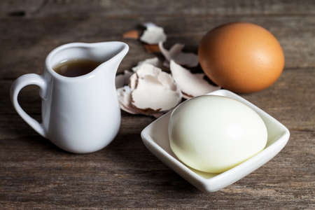 boiled eggs in small plate with sauce on the wood tableの写真素材