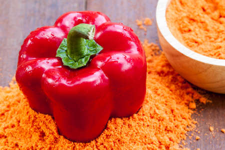 Powder and fresh red paprika on wooden tableの写真素材