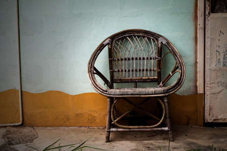 Wicker armchair with old wall background