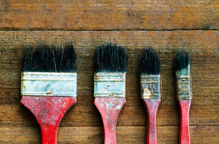 Old dirty vintage paint brushes on wooden background in vintage styleの写真素材