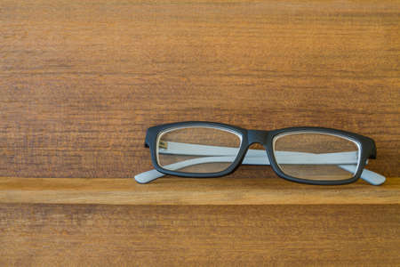 black hipster glasses on old wood shelfの写真素材