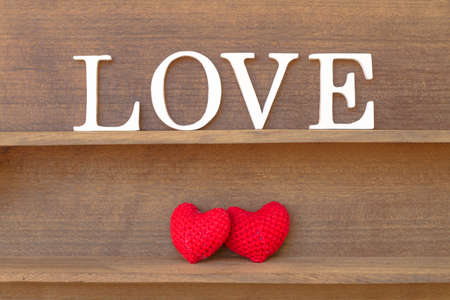 words " love " and heart shaped fabric on the wood shelfの写真素材