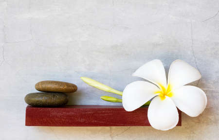 white plumeria flowers on red shelf. cement backgroundの写真素材