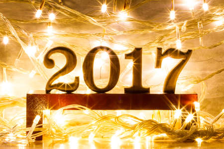 2017 year text wood on modern wooden shelf with sparkling bokeh and light effect backgroundの写真素材