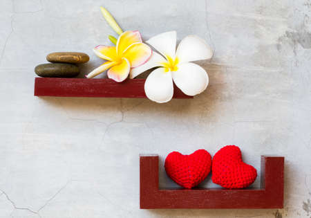 white and yellow plumeria flowers on red shelf. cement backgroundの写真素材