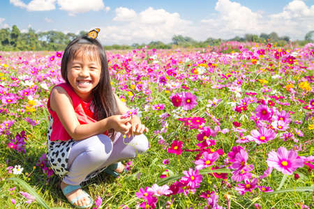 Little asian girl in cosmos flower fieldsの写真素材