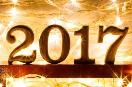 2017 year text wood on modern wooden shelf with sparkling bokeh and light effect backgroundの写真素材