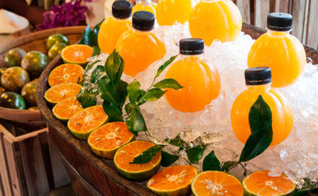 Fresh orange juice and ice on vintage wooden barrelの写真素材