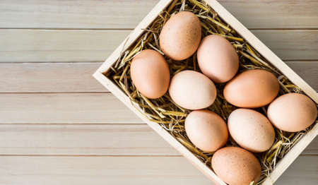 Chicken eggs in wood box on wood floorの写真素材