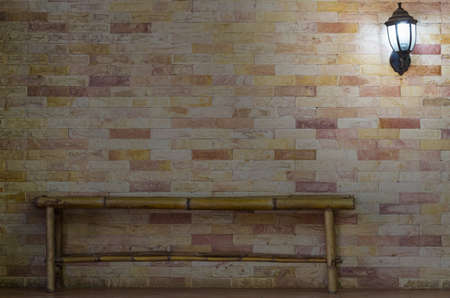 lantern on stone wall background with bamboo benchの写真素材