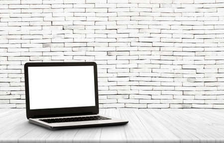 Laptop with blank screen on vintage wooden shelf with  white concrete vintage wall  backgroundの写真素材