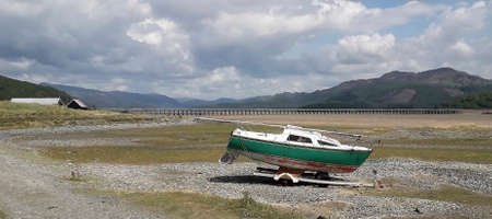 tide out with boat on a trailer before mountain viewsの写真素材