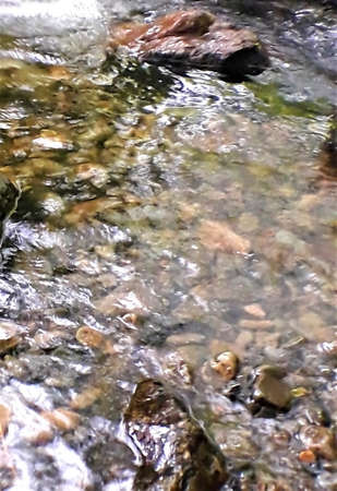 stream rushing over pebbles and stonesの写真素材