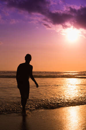 The silhouette of a young man on the beach in Bali, Indonesiaの写真素材