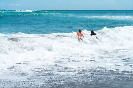 beautiful surf couple on a beach of indonesiaの写真素材