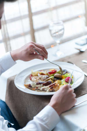Man's hands with healthy vegetarian meal on table in restaurant.の写真素材