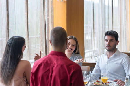 Two couples eating dinner restourant, having conversation, and drinking champagneの写真素材